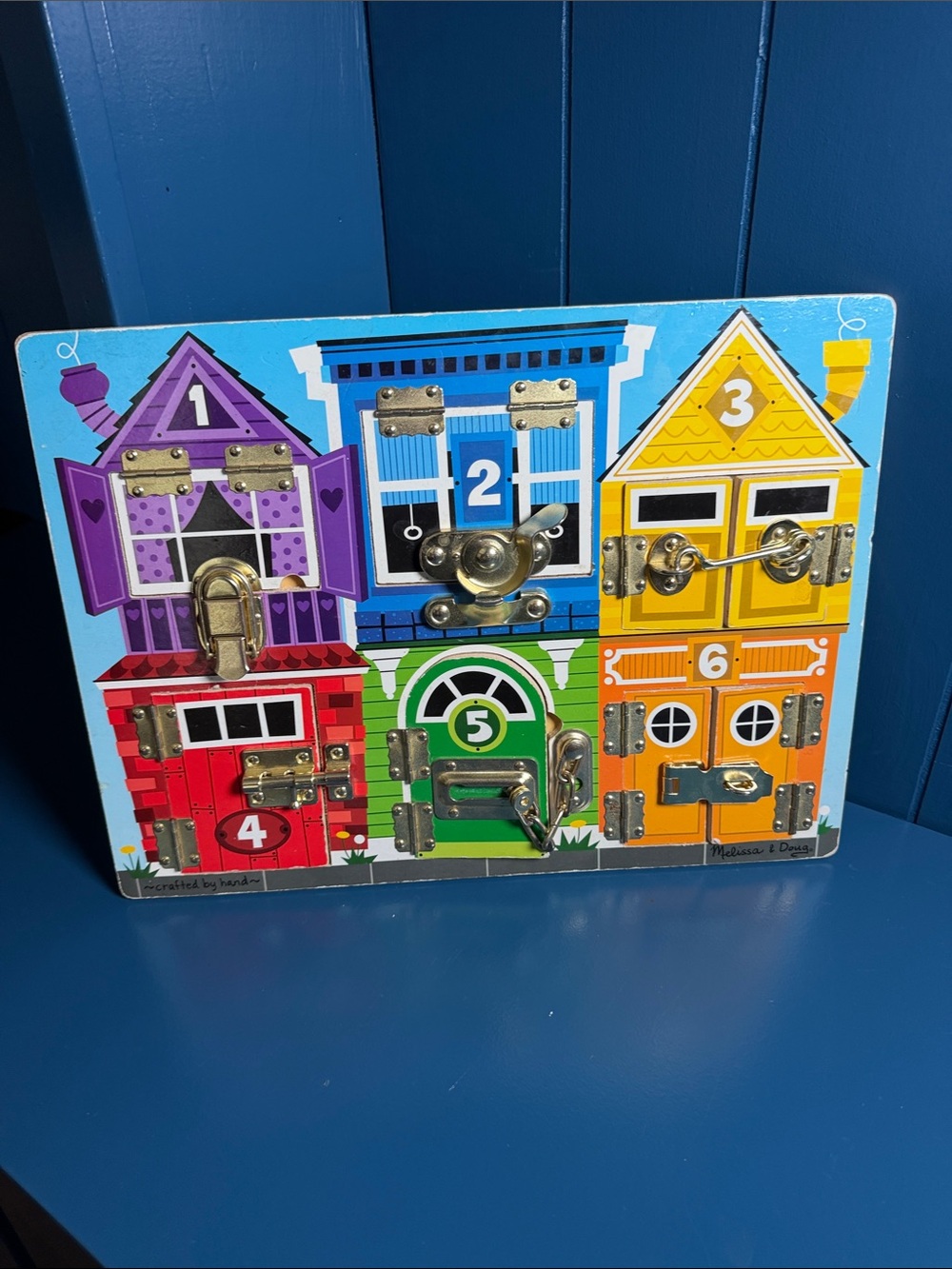Melissa & Doug Wooden Lockboard Toy in Purple, Blue, Yellow, Red, Green, Orange